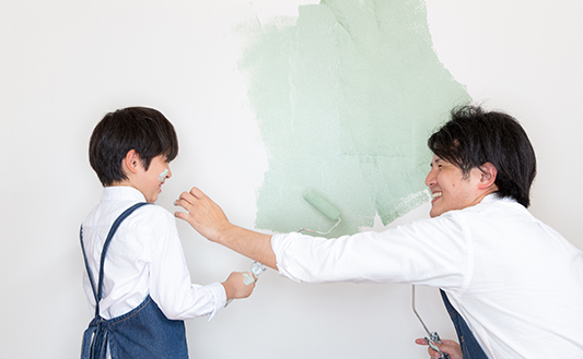 親子で子供部屋のオガファーザーにデュブロン塗装している様子